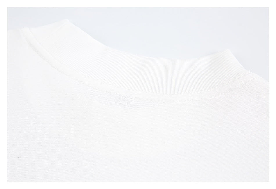 Close-up of a white garment's ribbed crew neckline and stitched collar seam.