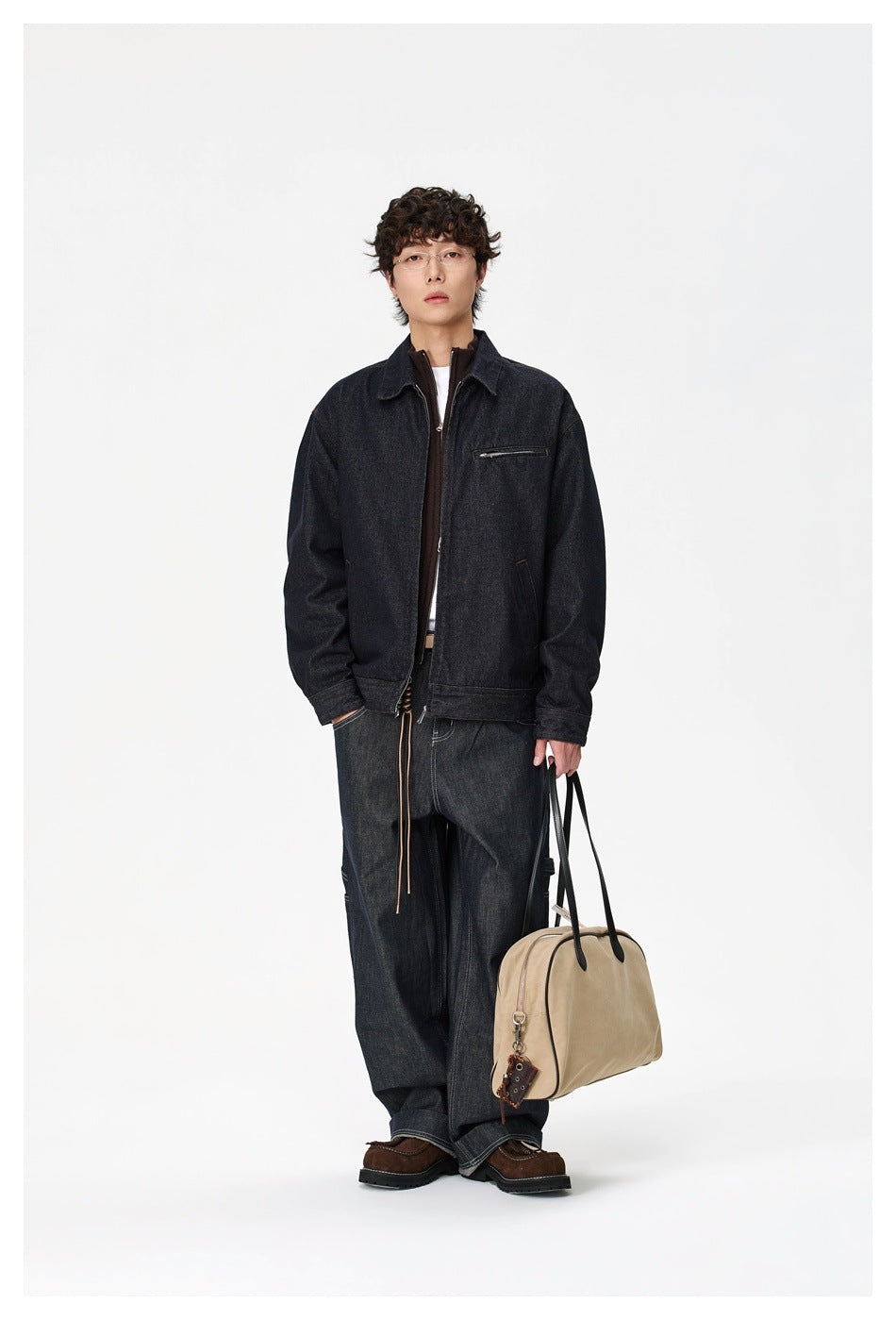 Full-length model wearing a dark indigo denim jacket with a zip front and chest pocket, styled with dark jeans.