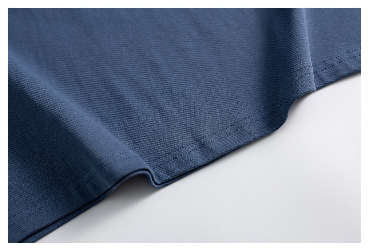 Close-up of the slate-blue T-shirt's bottom hem and double-row stitching.
