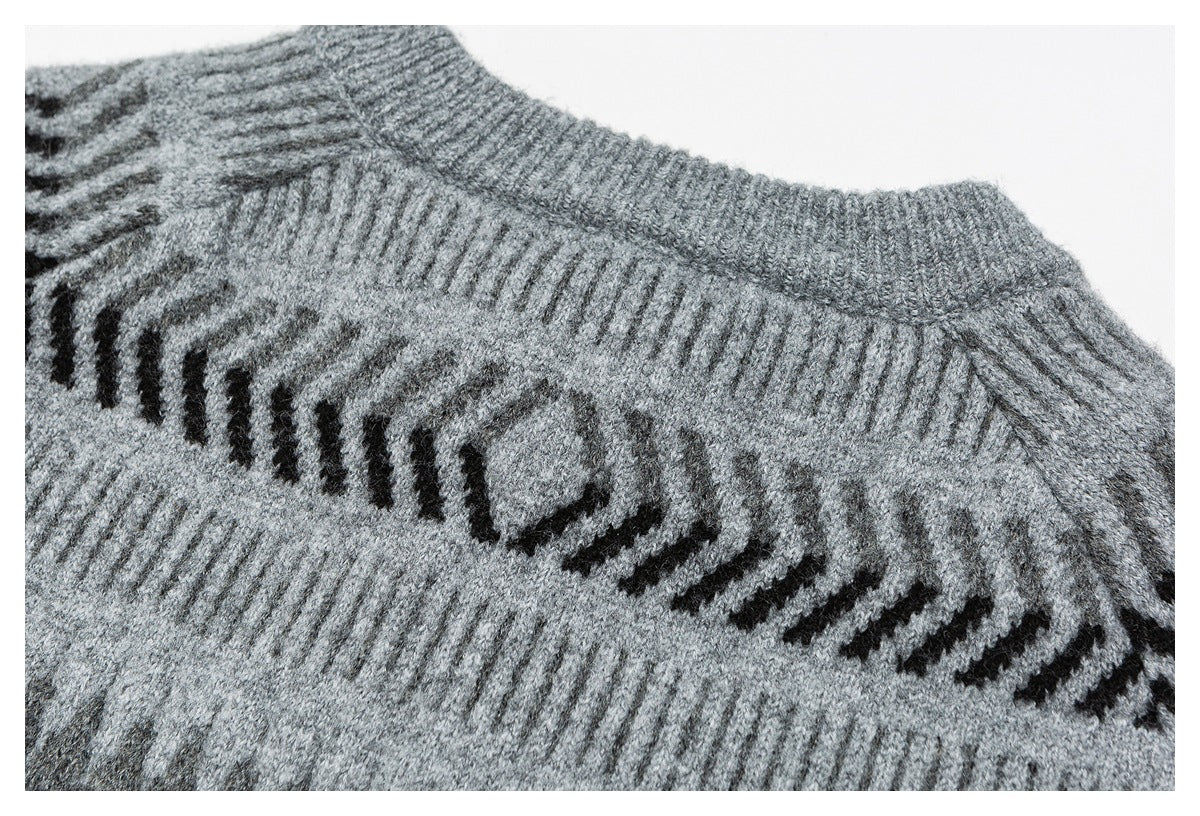 Close-up of a gray sweater's ribbed neckline and dark patterned knit band.