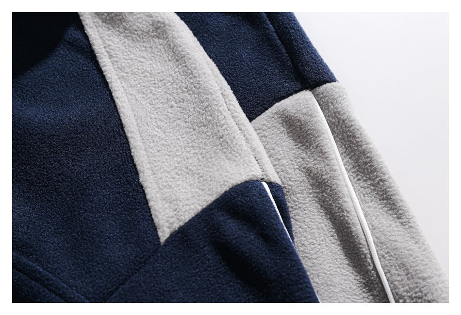 Close-up of navy and light gray fleece color-block panels with a contrasting seam.