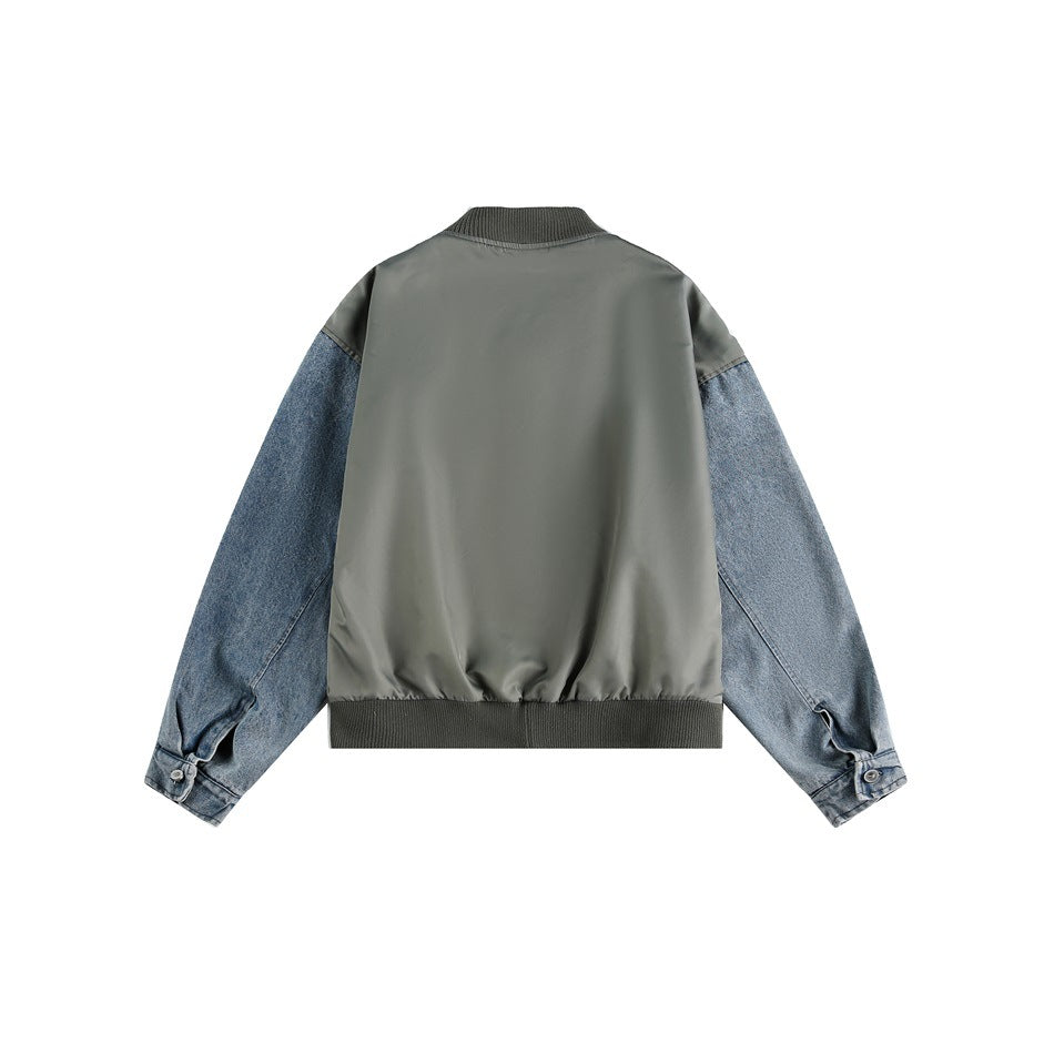 Back view of an oversized olive-gray jacket with blue denim sleeves, a ribbed collar and hem, displayed on white.