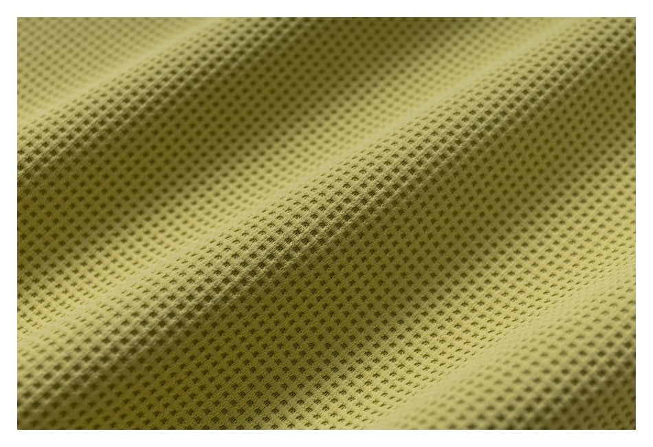 Close-up of yellow-green fabric with a raised, evenly spaced waffle texture.