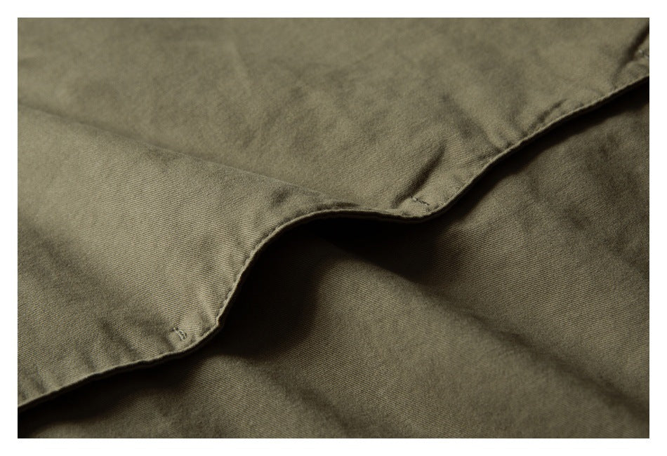 Close-up of a flap pocket on the olive jacket.