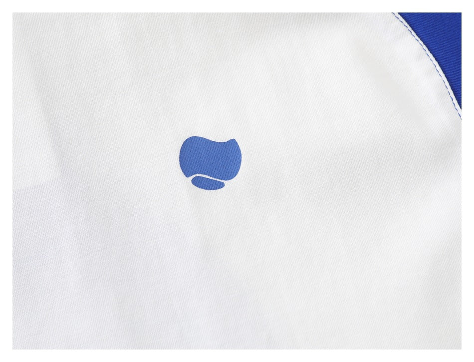 Close-up of a small blue emblem printed on the white chest of the T-shirt.