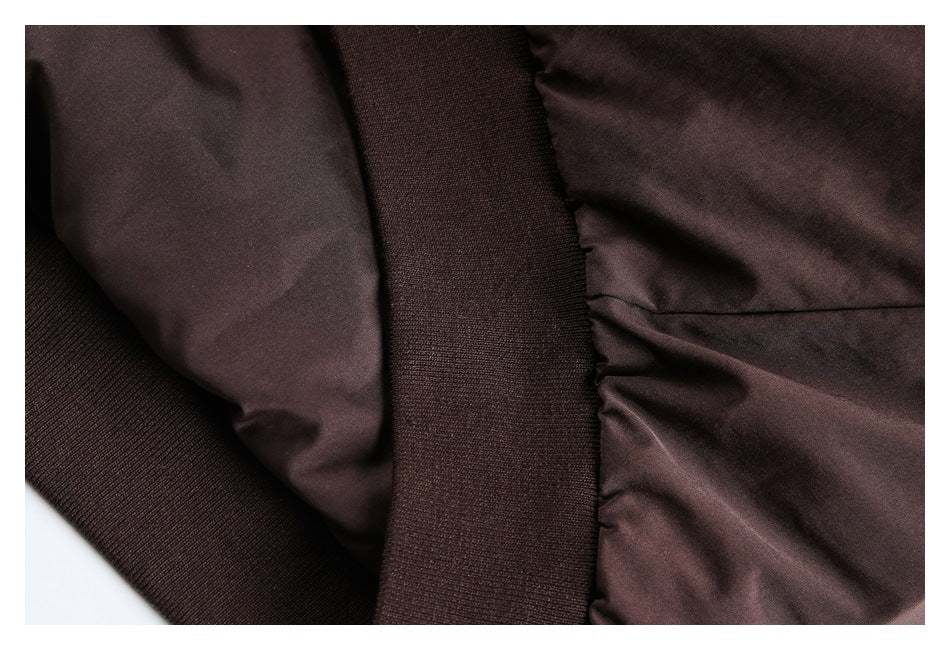 Close-up of a dark brown jacket sleeve and ribbed cuff seam.