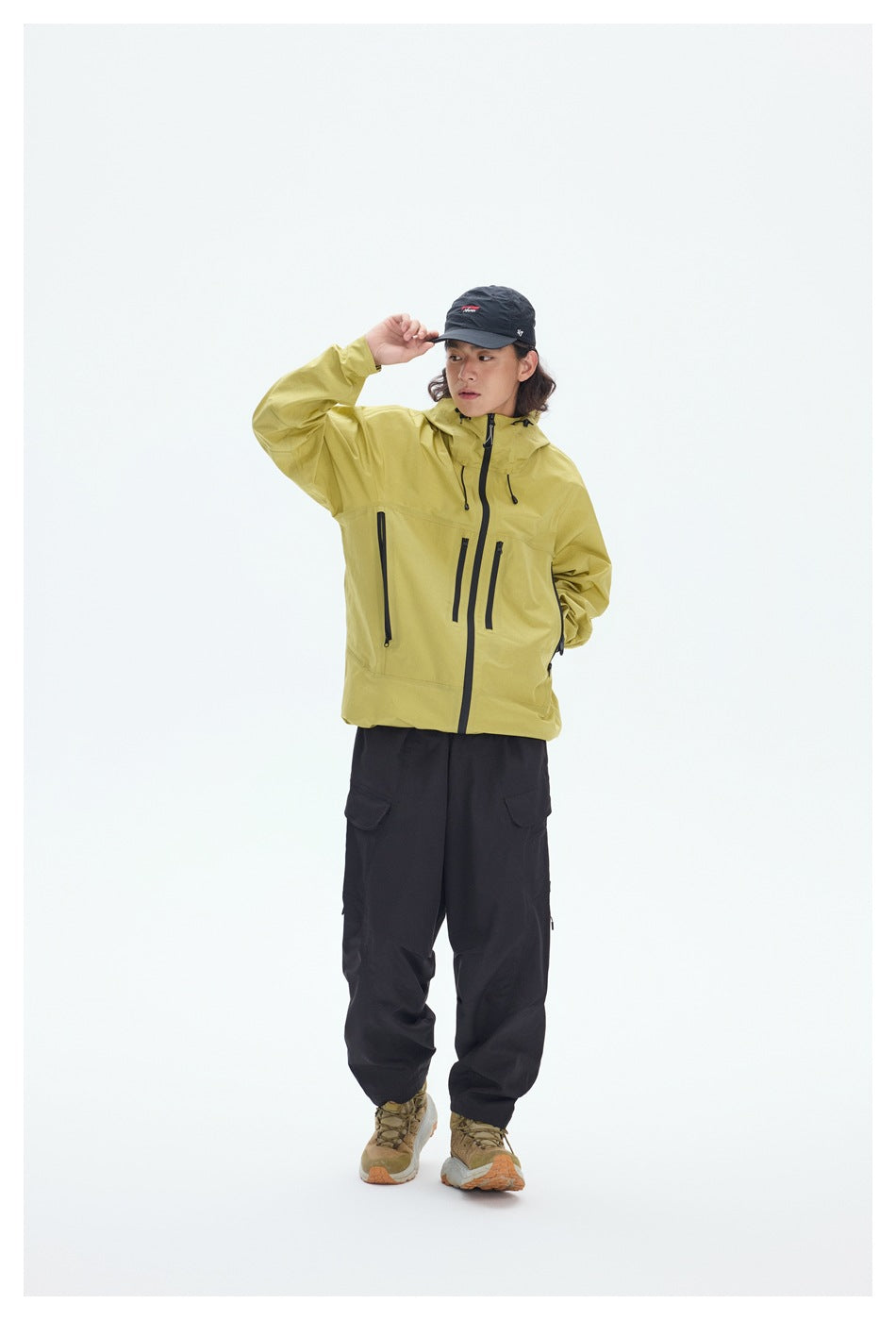 Full-length model wearing a yellow hooded jacket with black zippers and black cargo pants.