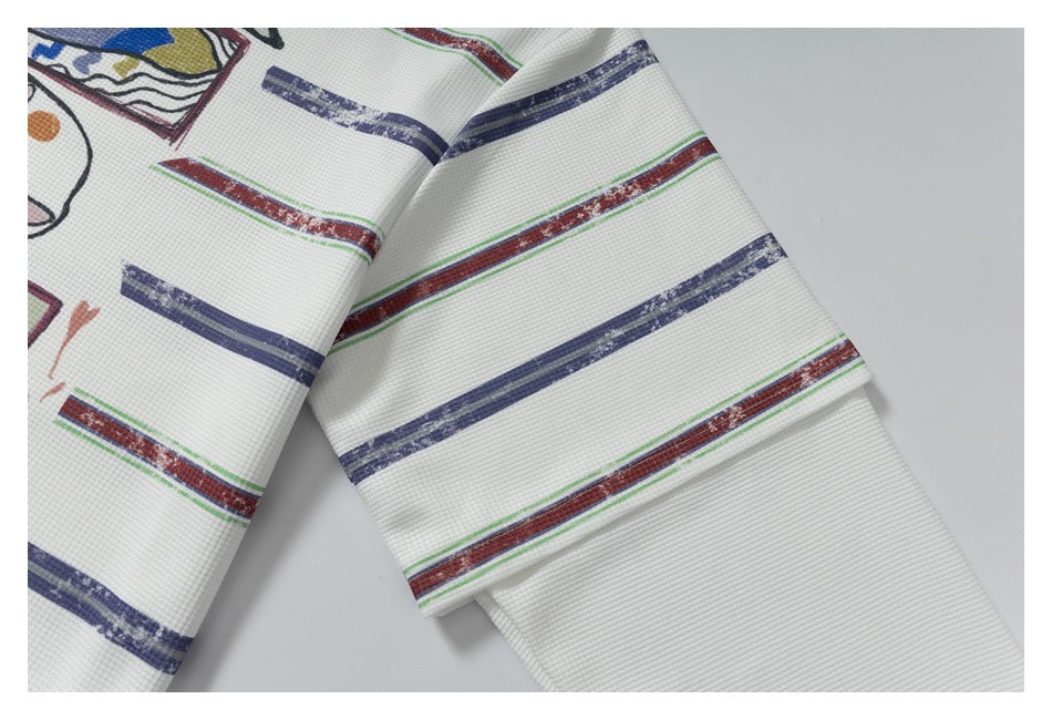 Close-up of white textured fabric with navy, red and green stripes and part of a colorful graphic print.