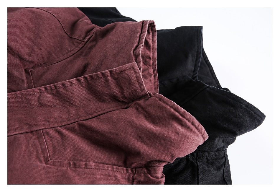 Close-up of burgundy and black jackets showing overlapping fabric panels and stitched seams.