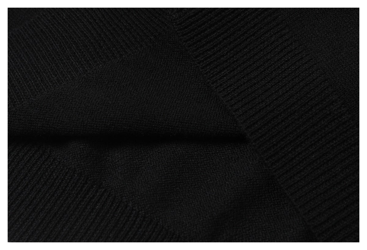 Close-up of black knit fabric showing a ribbed seam and contrasting knit textures.
