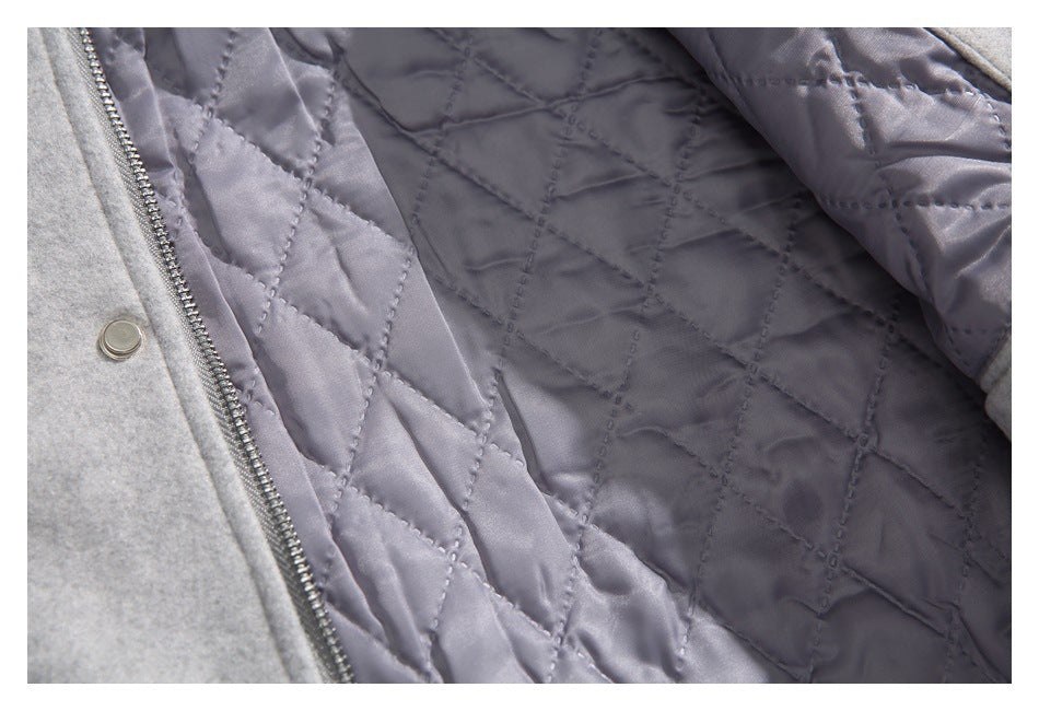 Close-up of the open coat showing its gray diamond-quilted lining and zipper.