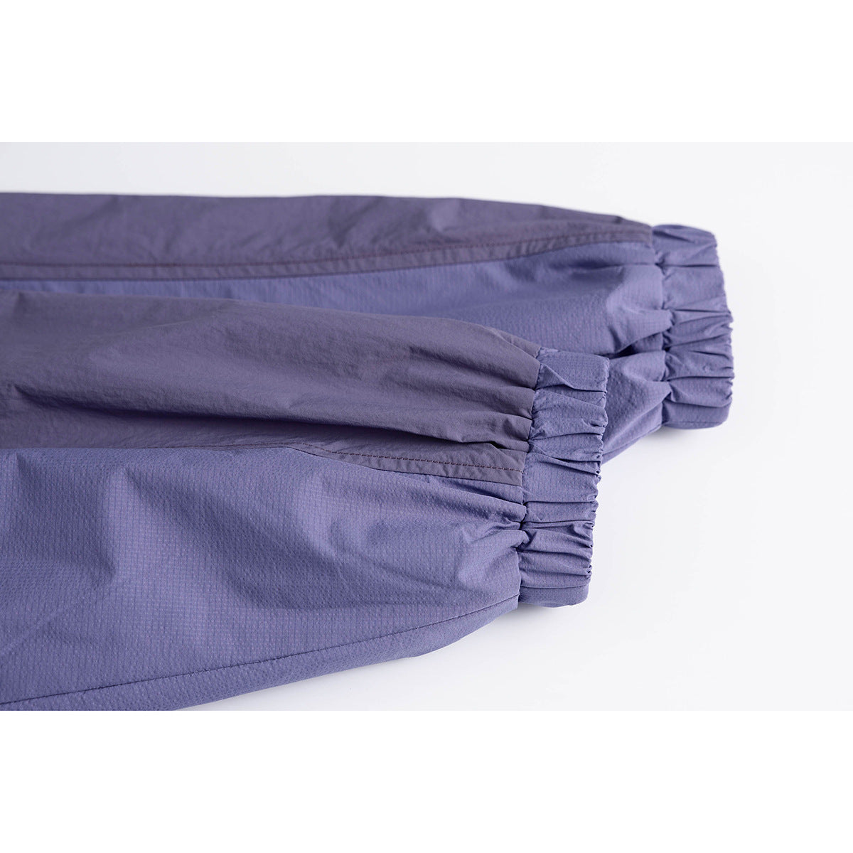 Close-up of blue-violet jacket sleeves and gathered elastic cuffs.