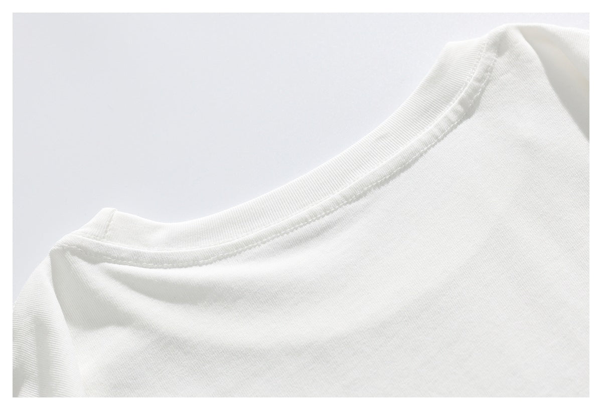 Close-up of the round neckline and shoulder seam of a white shirt.