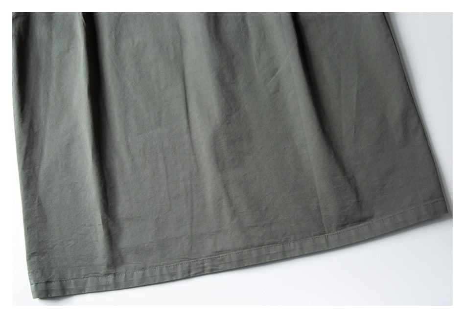 Close-up of the charcoal-gray garment's lower panel and stitched hem.