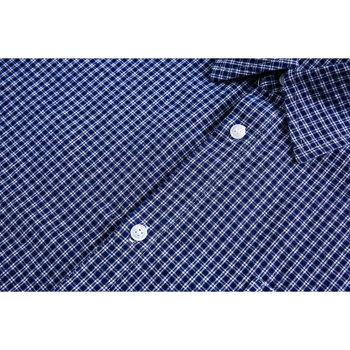 Close-up of two white buttons on the placket of a navy-and-white checked shirt.
