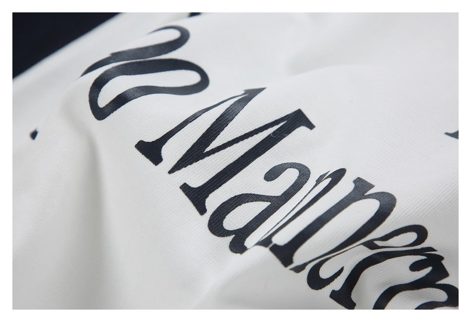 Close-up of large black stylized lettering printed across white garment fabric.