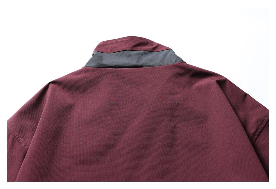 Back close-up of a burgundy jacket with a gray collar panel and subtle tonal graphic.