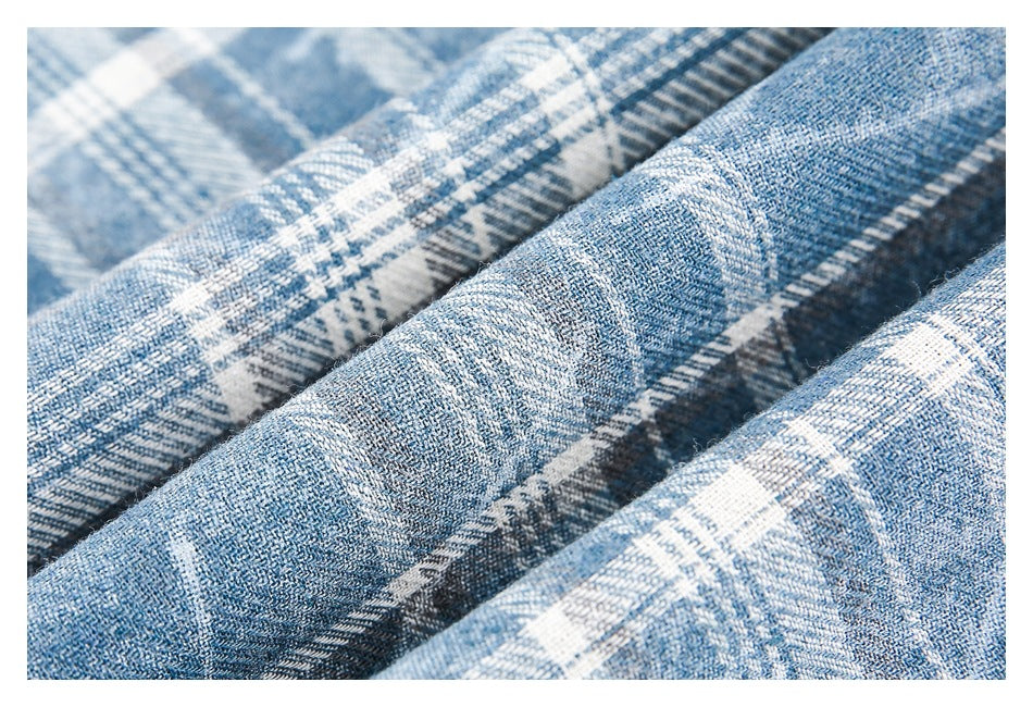 Macro view of the textured blue and white plaid fabric and its woven pattern.