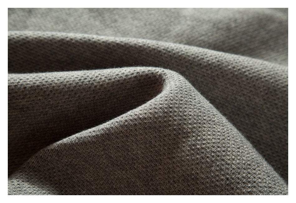 Close-up of draped gray knit fabric showing its textured surface.