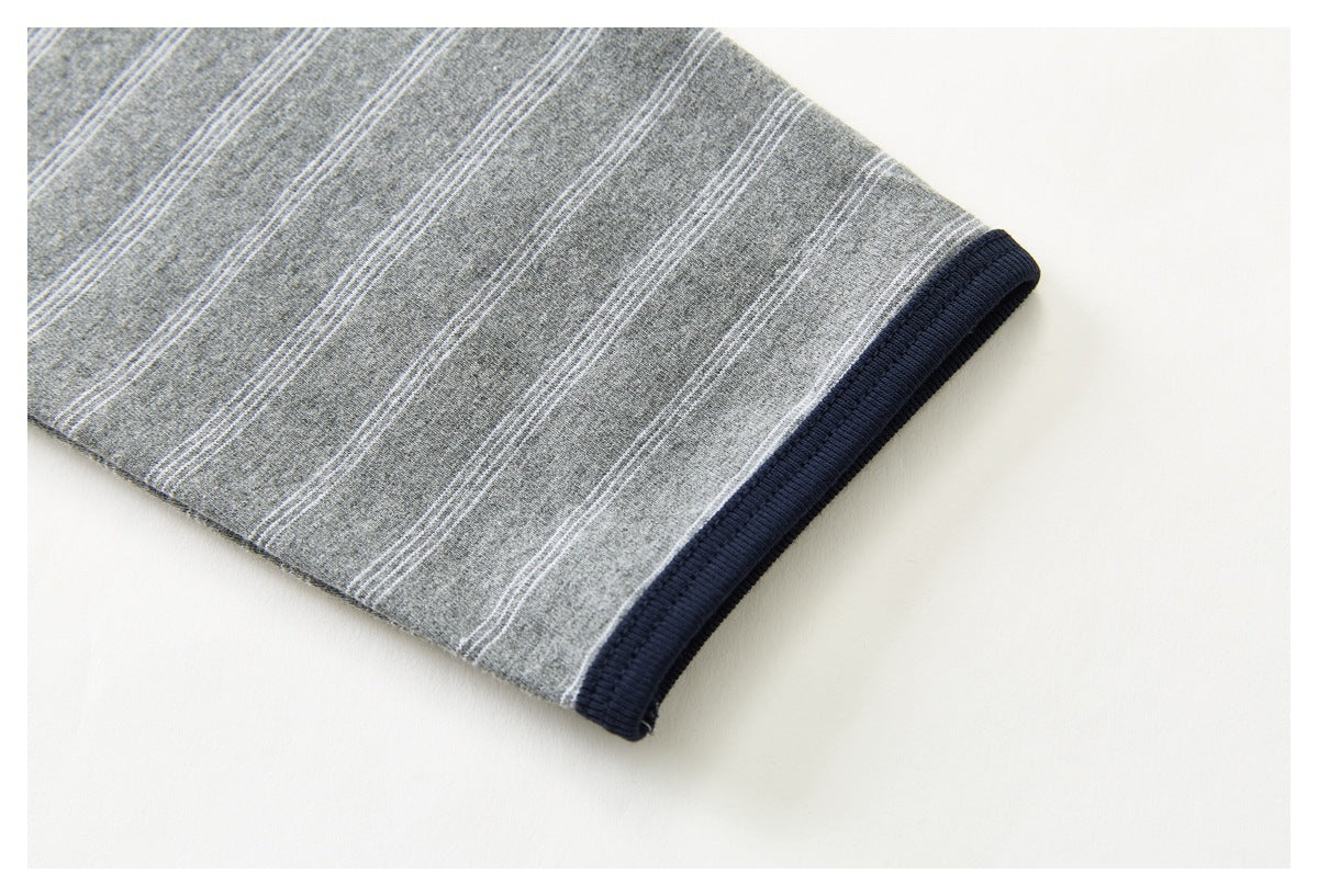 Close-up of a gray, fine-striped sleeve ending in a dark navy ribbed cuff.