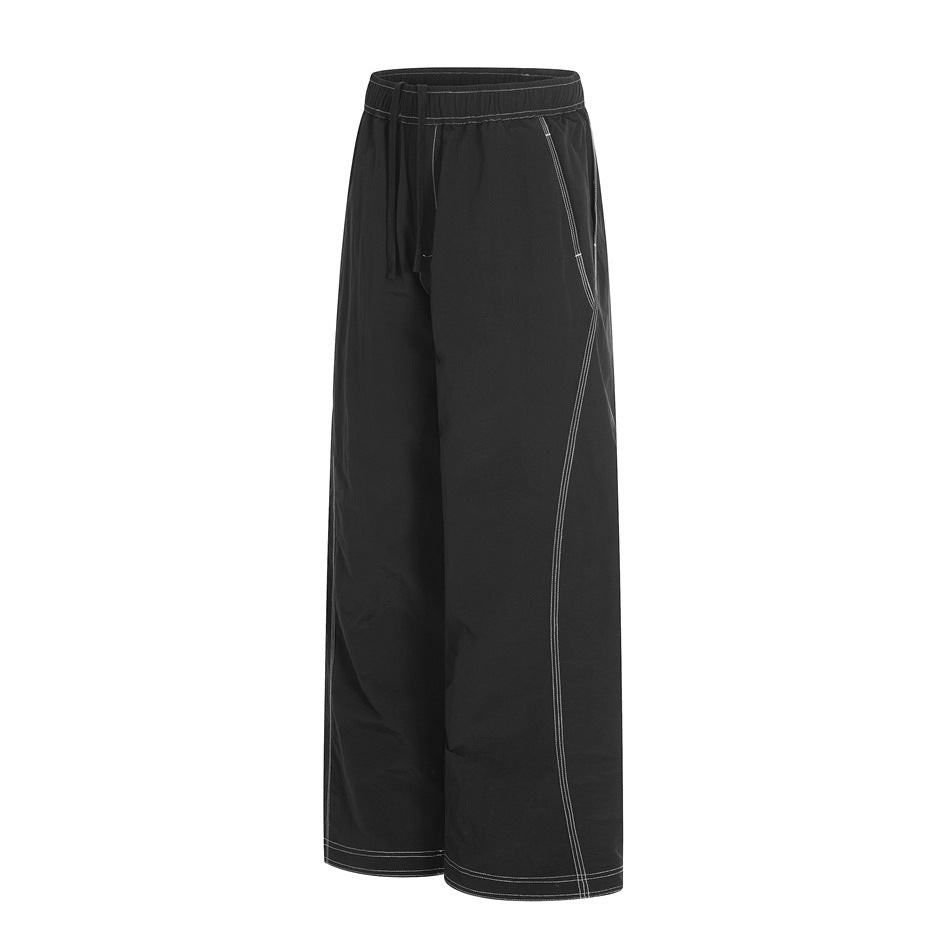 Front view of black wide-leg pants with an elastic drawstring waist and contrasting light seam stitching.