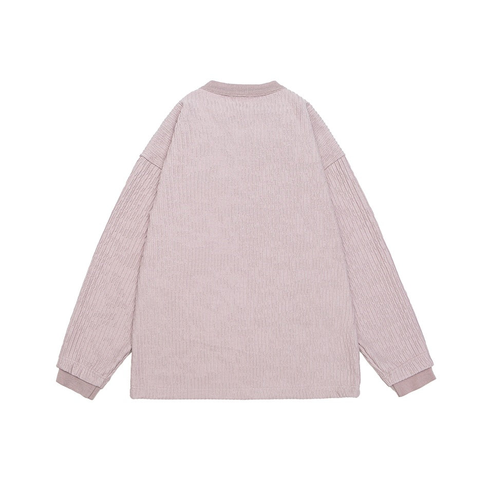 Back view of a dusty pink ribbed long-sleeve top with a round neckline and ribbed cuffs.