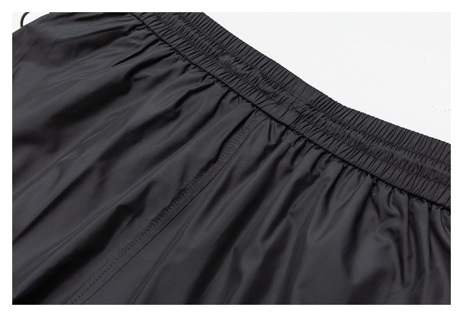 Close-up of black shorts showing the gathered elastic waistband and stitched seams.