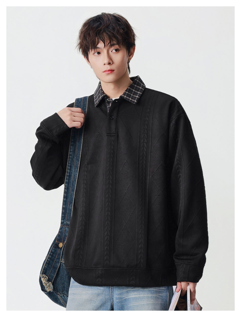 Model wearing an oversized black pullover with a plaid collar, button placket, and raised cable and diamond patterns.