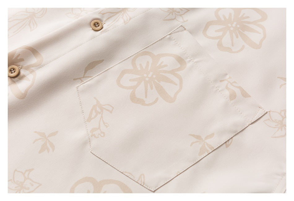 Close-up of a beige floral shirt's chest pocket, stitching, and tan buttons.