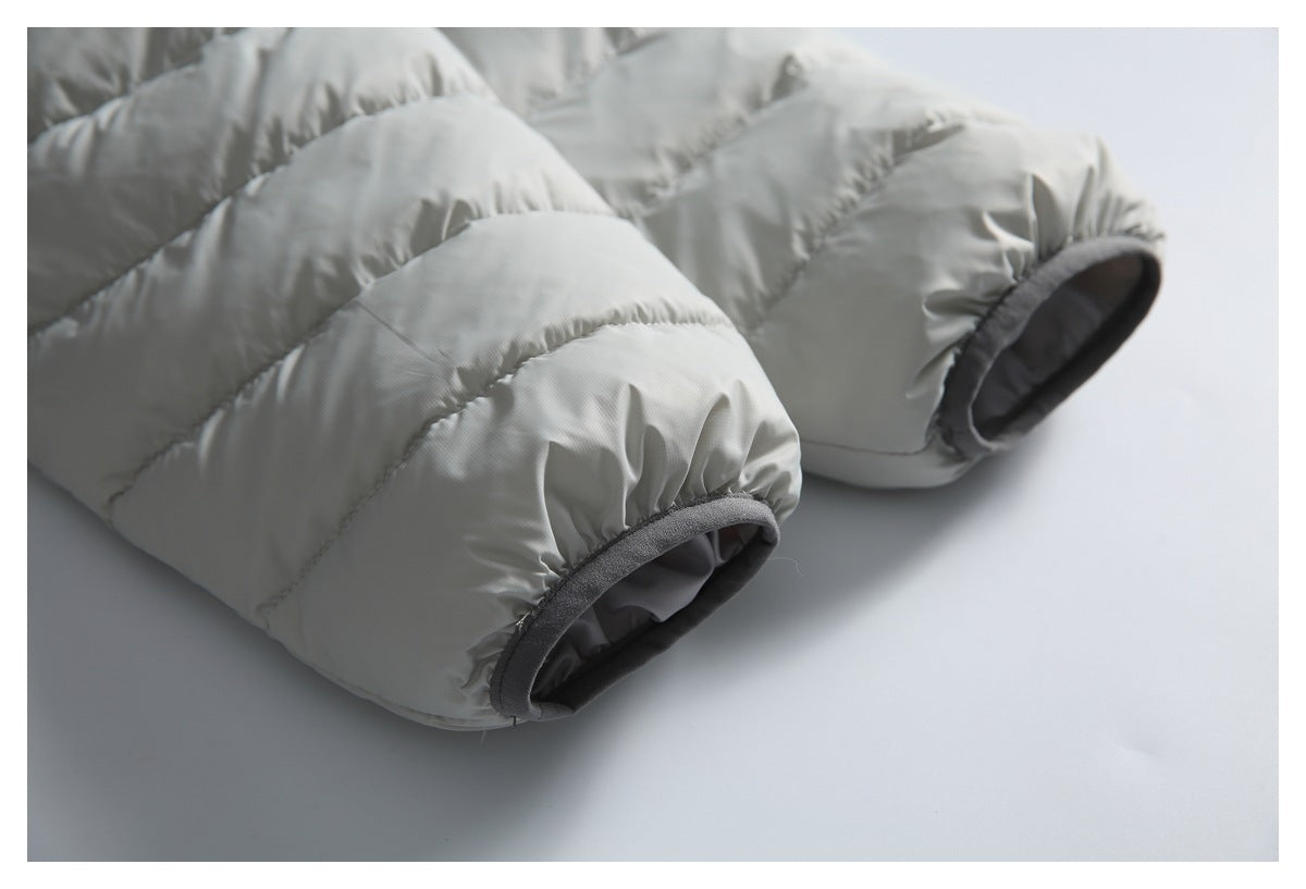 Close-up of a light gray quilted puffer jacket with gathered cuffs finished in dark gray trim.