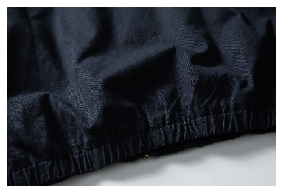 Close-up of a gathered elastic hem on a dark navy jacket.