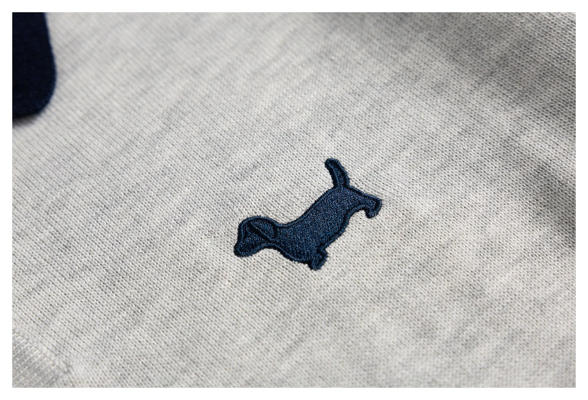 Navy embroidered animal silhouette on the light gray knit fabric of the polo.