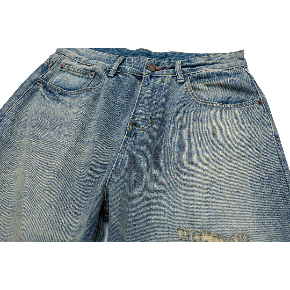 Close-up of the front of faded blue jeans showing the waistband, button, pockets and a distressed patch near the thigh.