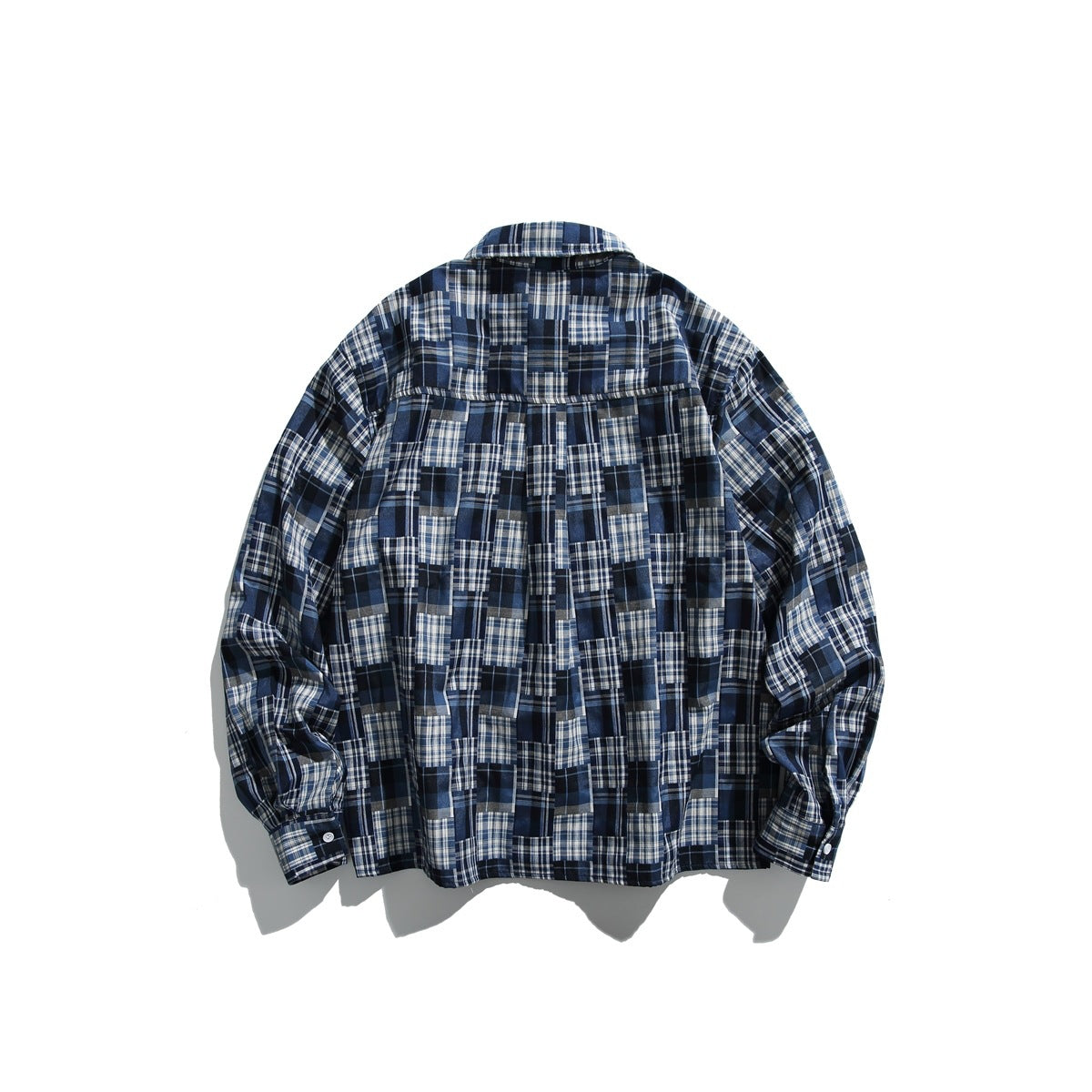 Back view of a long-sleeved navy, blue, gray, and white plaid button-up shirt laid flat against white.