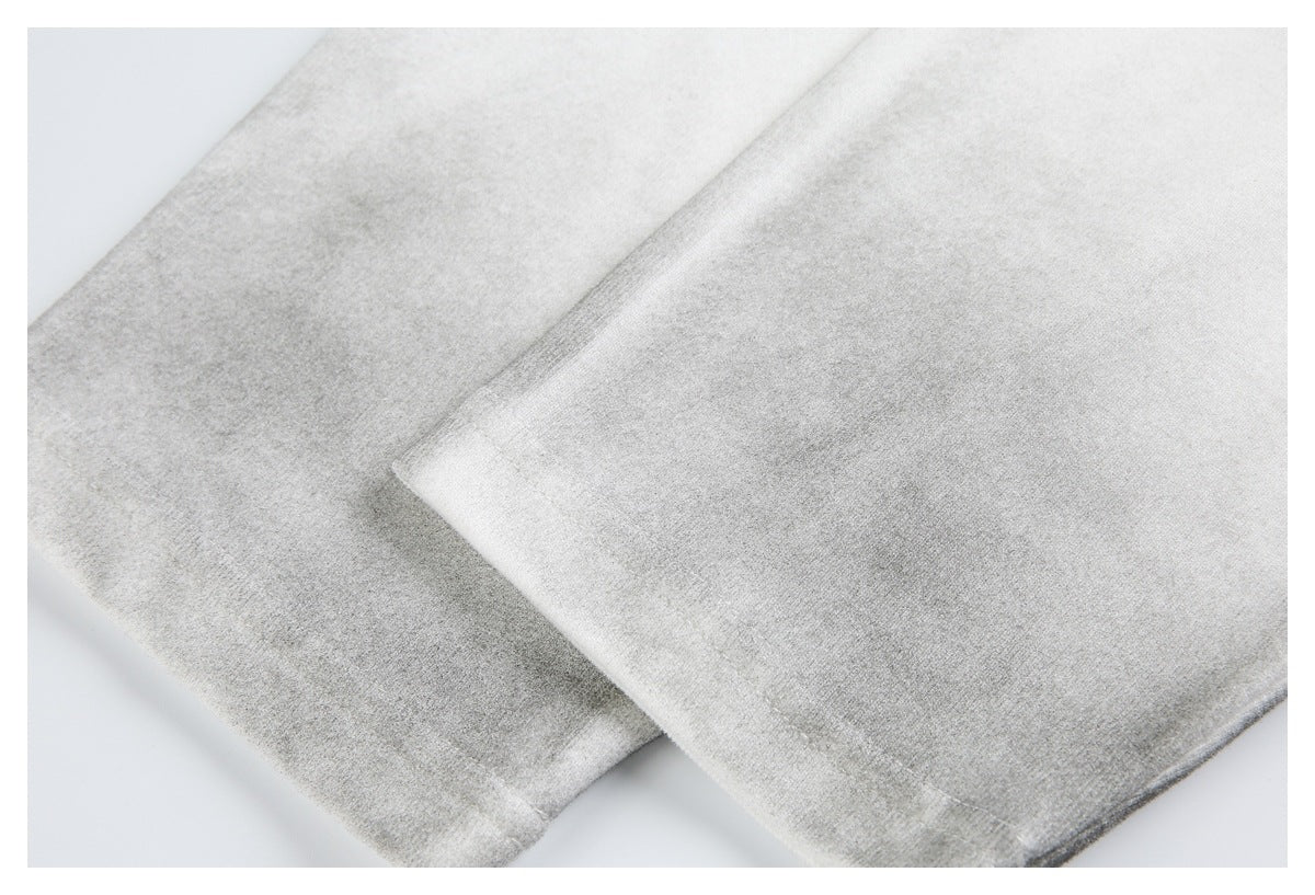 Close-up of overlapping off-white shirt hems with visible stitching.