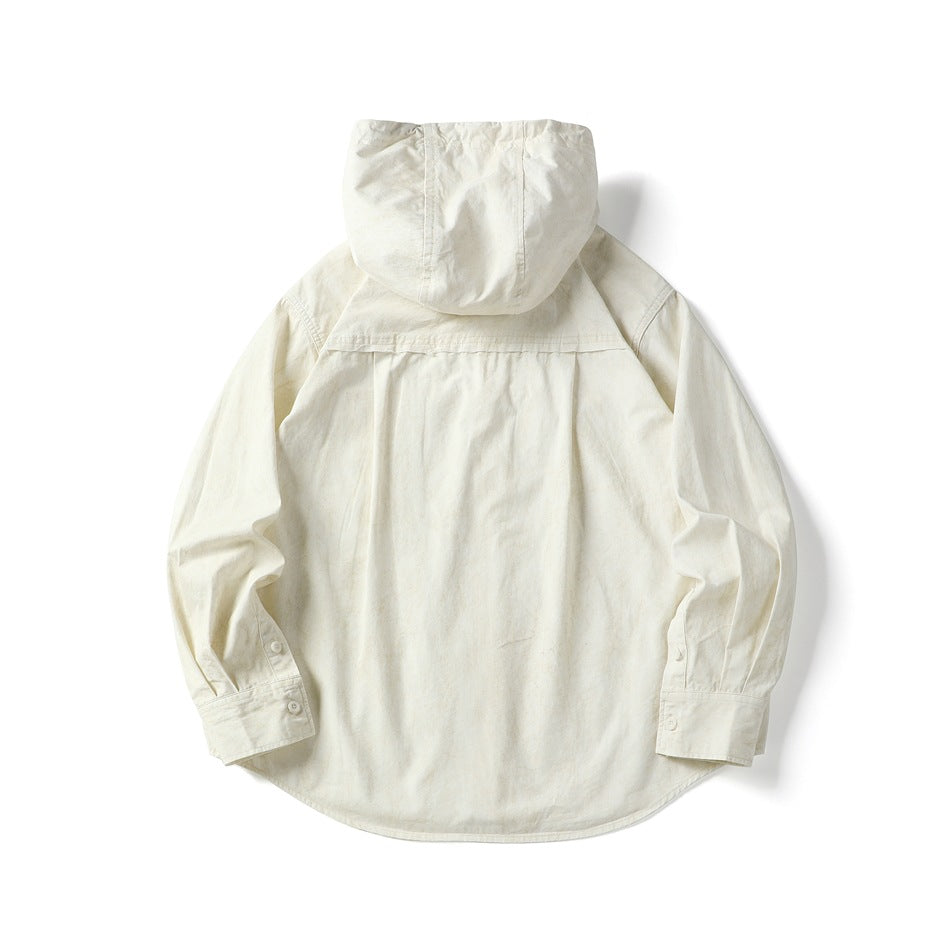 Back view of an ivory hooded shirt with long sleeves, button cuffs, and a curved hem.