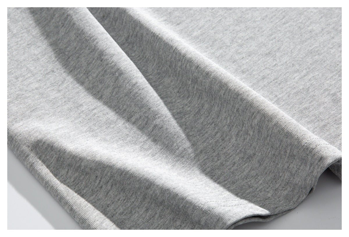 Close-up of folded light gray shirt fabric and a stitched hem.