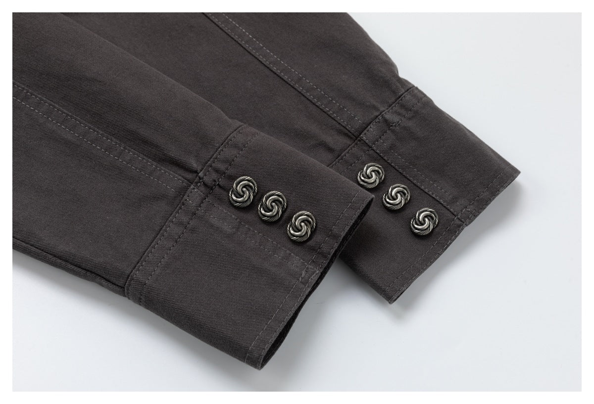 Close-up of dark charcoal jacket cuffs with decorative silver-tone buttons and stitched seams.