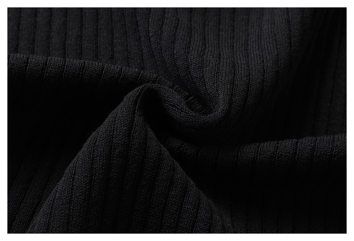 Close-up of black rib-knit fabric gathered into folds.