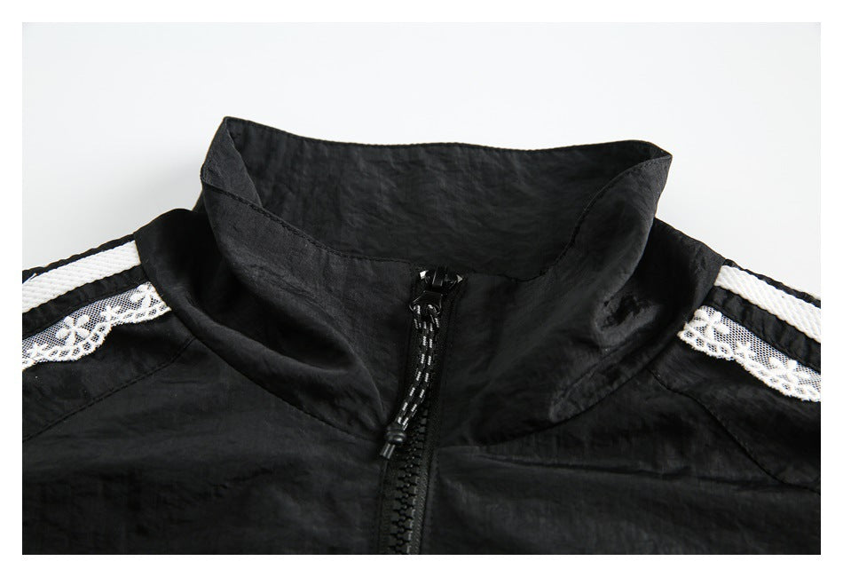 Close-up of the black jacket's high collar, front zipper, and white striped lace shoulder trim.