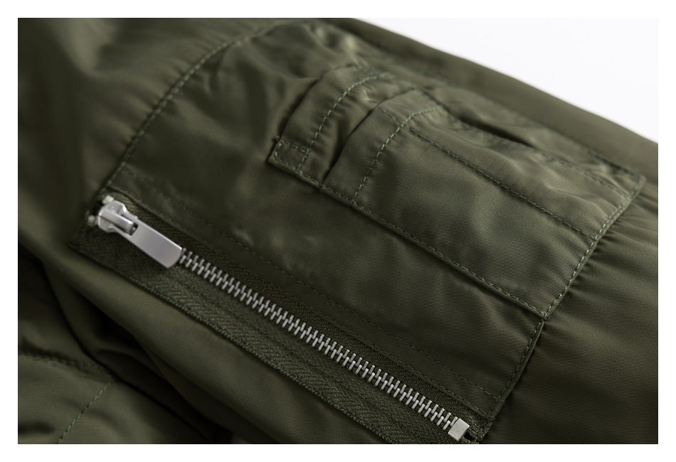 Close-up of an olive jacket pocket with a silver zipper and stitched flap.