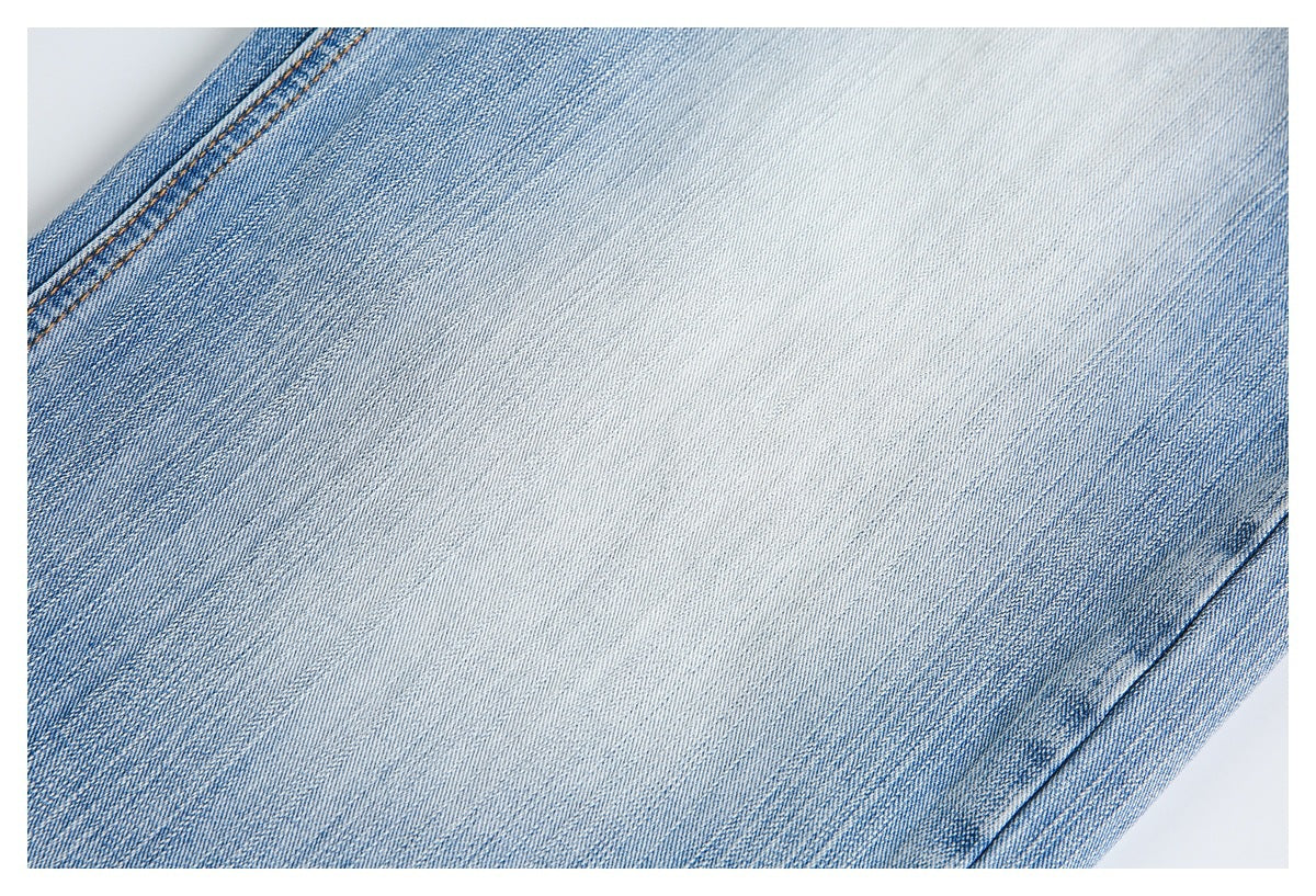 Close-up of pale blue faded denim showing the fabric wash and diagonal twill texture.