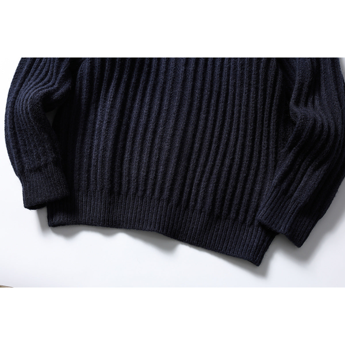 Close-up of the dark navy cardigan's ribbed lower body, hem, and sleeve cuffs.