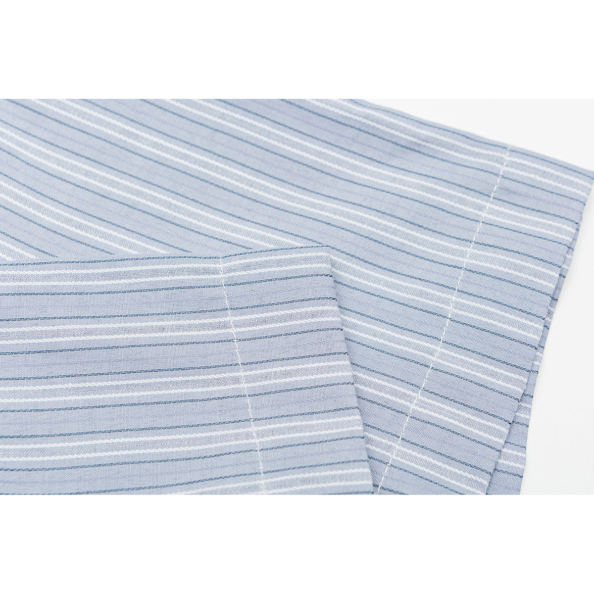 Close-up of a light blue striped shirt sleeve and cuff with white and dark blue lines.