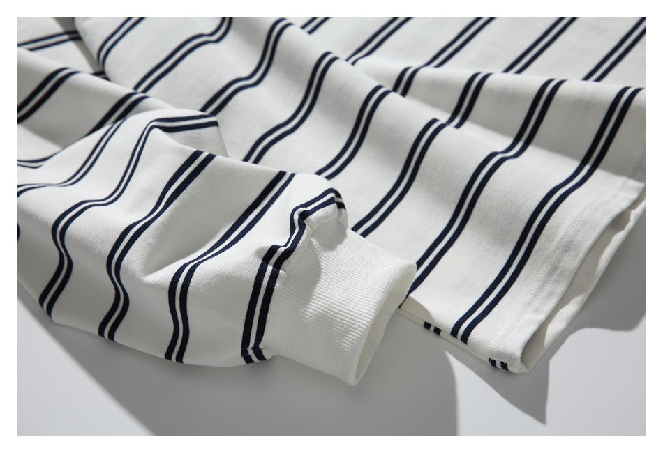 Close-up showing a ribbed cuff and stitched hem on the off-white top with navy stripes.