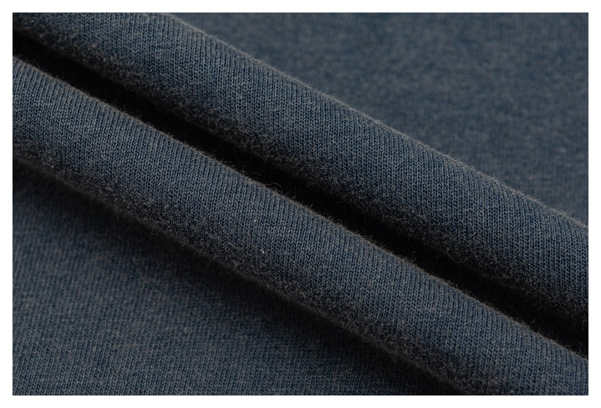 Extreme close-up of dark blue-gray shirt fabric folded to show its knit texture.