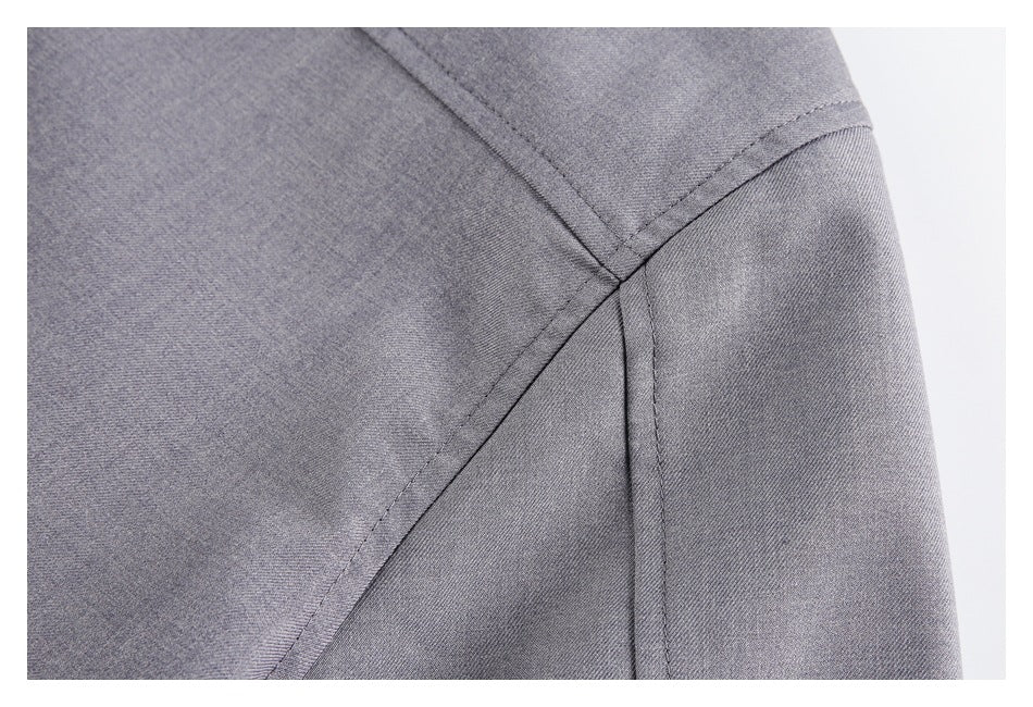 Close-up of gray garment panels meeting at a stitched seam.