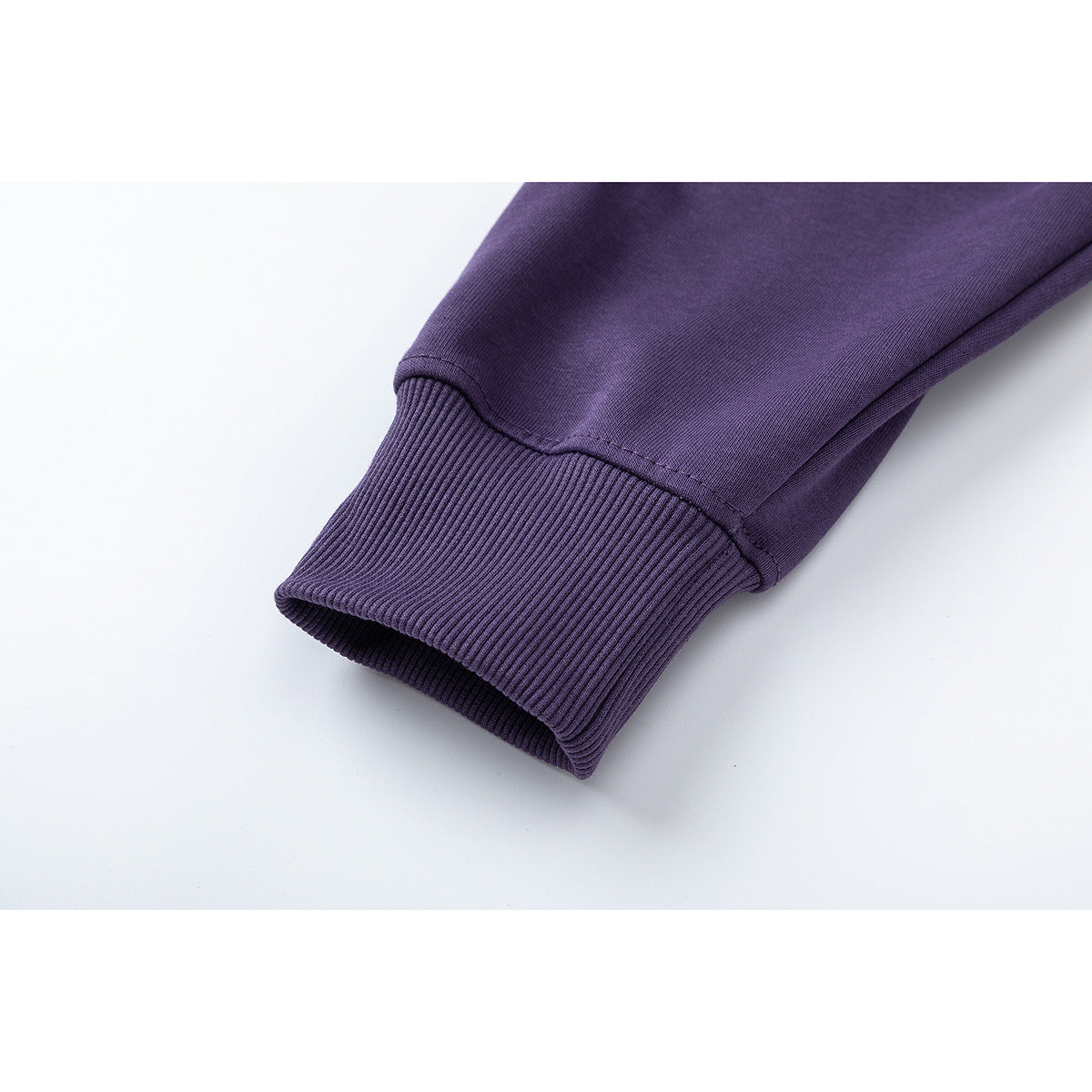 Close-up of a purple sweatshirt sleeve ending in a wide ribbed cuff.
