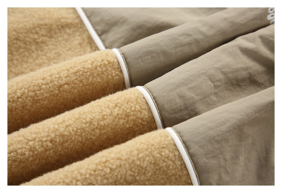 Close-up of tan plush fabric joined to taupe fabric with white piping.