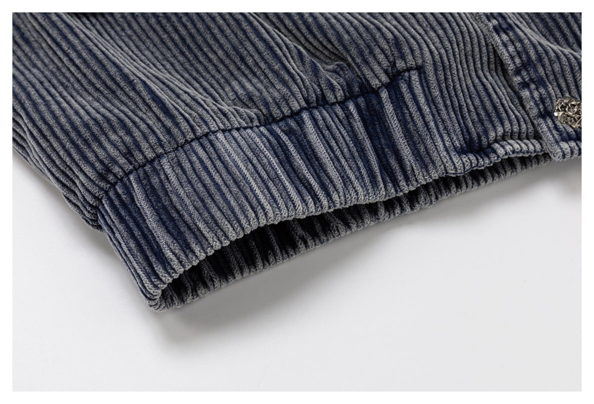 Close-up of a blue-gray ribbed garment edge with gathered stitching and a metal button.